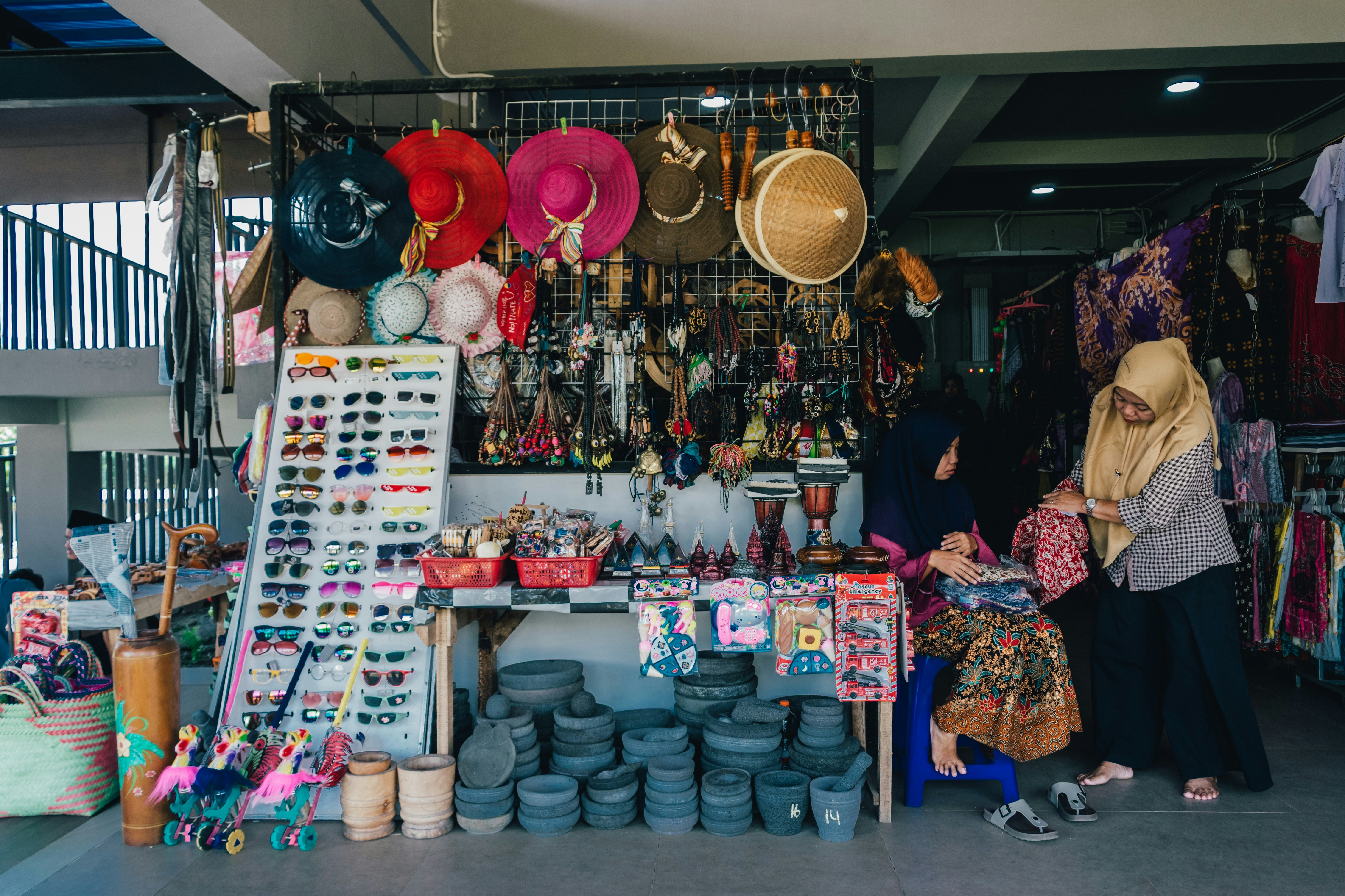 People are shopping at a colorful souvenir stand.