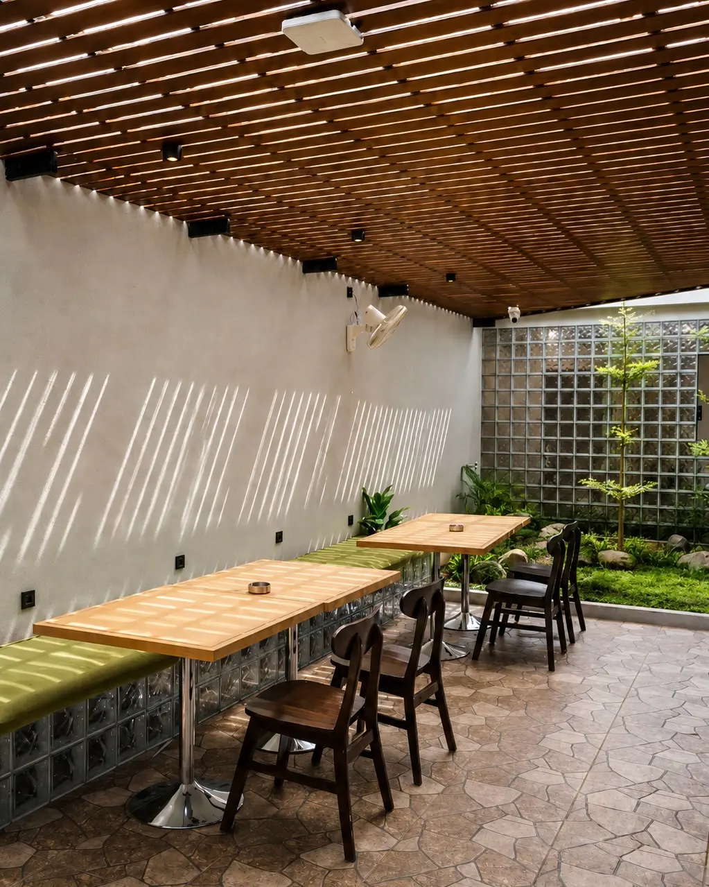 Area semi-outdoor ARAH Coffee dengan meja kayu dan atap kisi