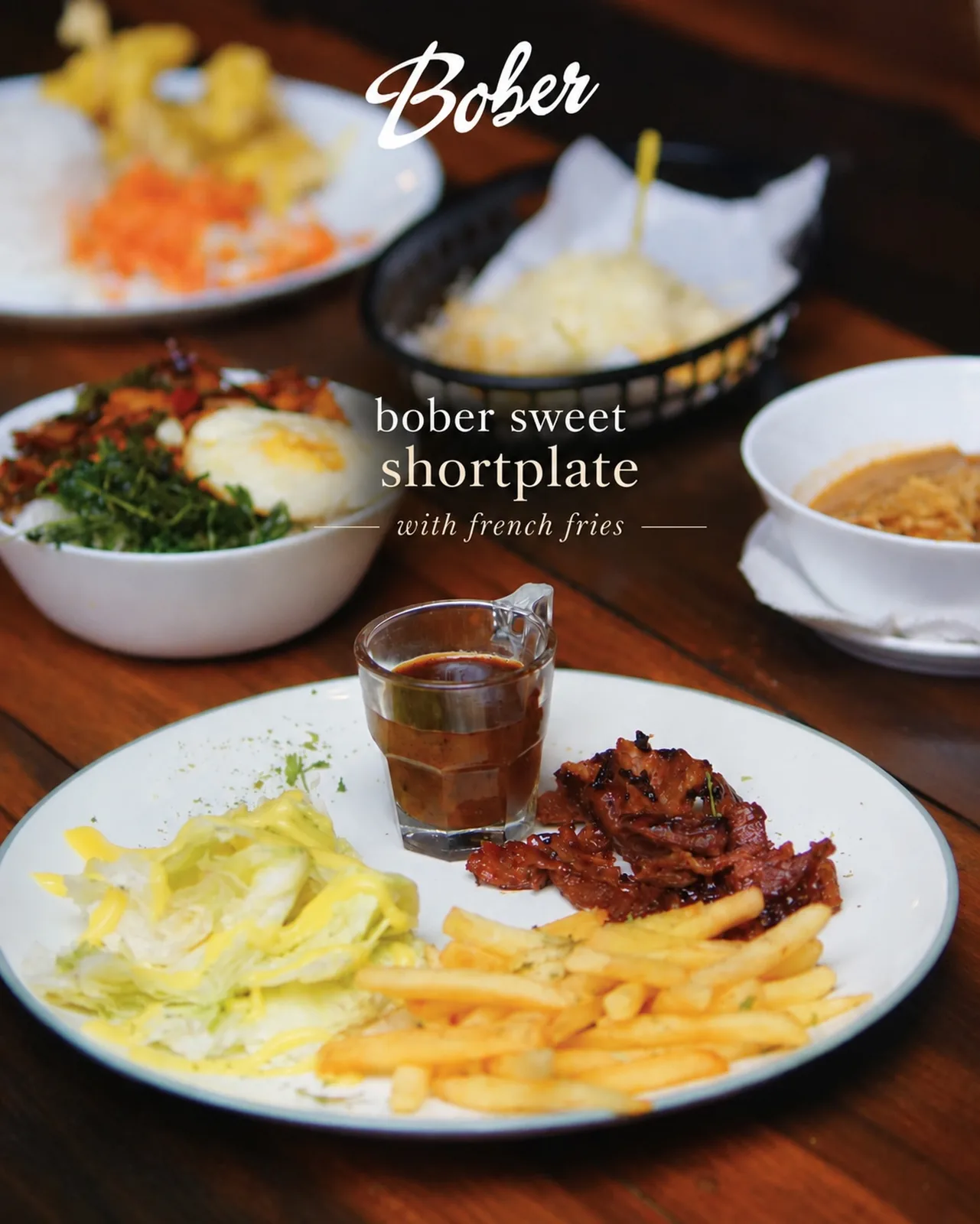 Hidangan shortplate, kentang goreng, dan nasi di meja kayu Bober Cafe