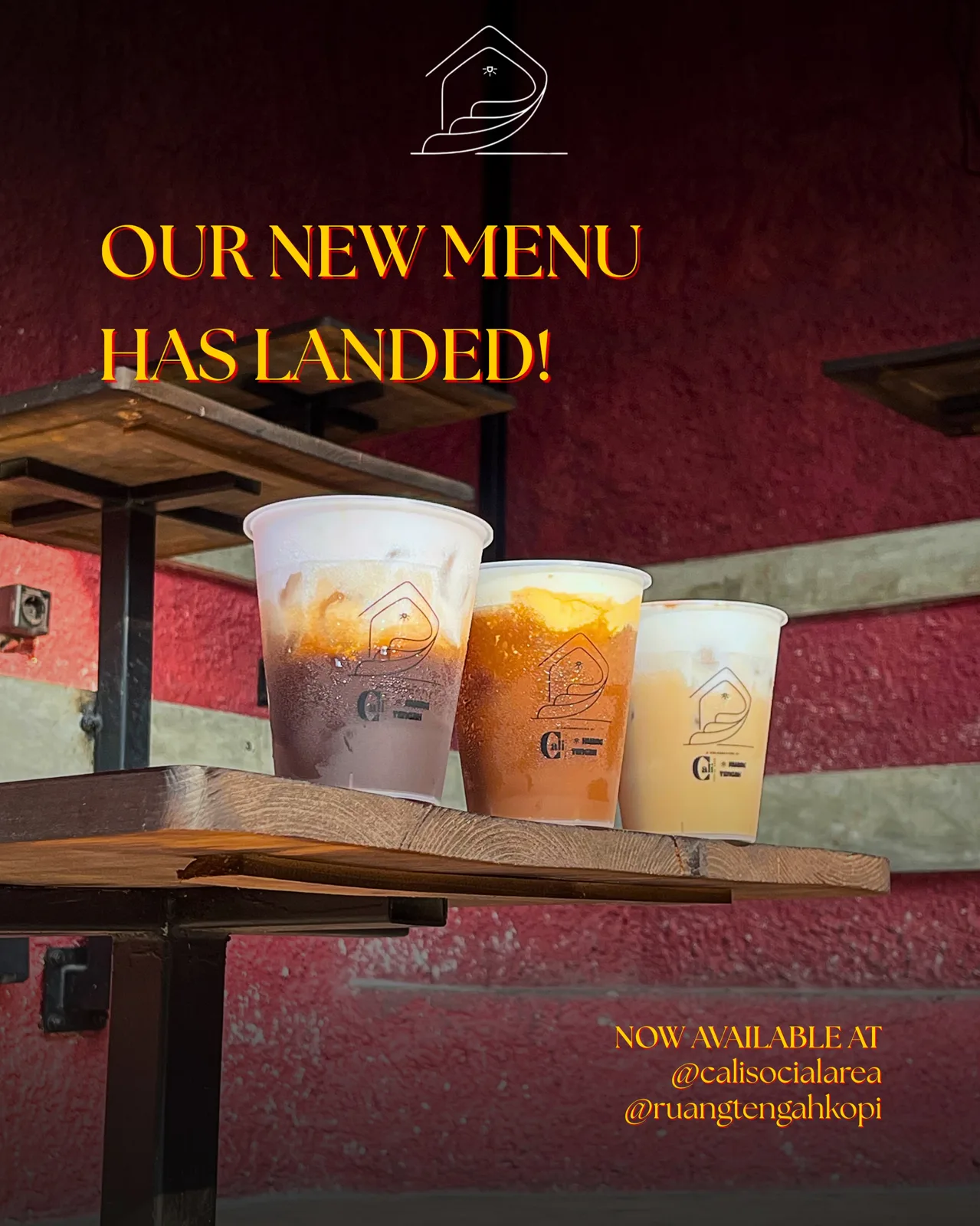 Tiga gelas minuman di meja kayu dengan tulisan Our New Menu Has Landed