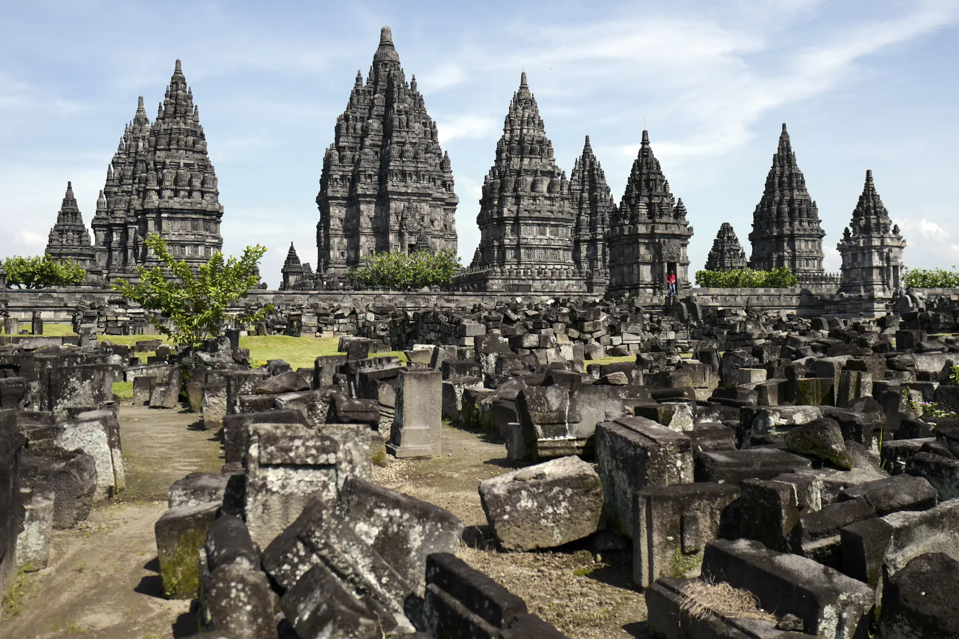 Kompleks Candi Prambanan dengan deretan candi utama menjulang di belakang reruntuhan candi perwara