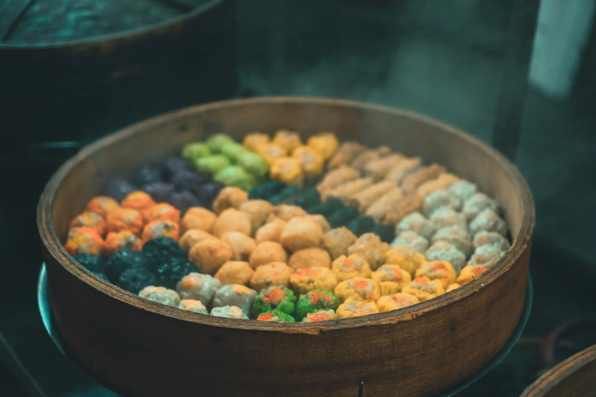 Aneka dimsum warna-warni tersusun dalam kukusan bambu