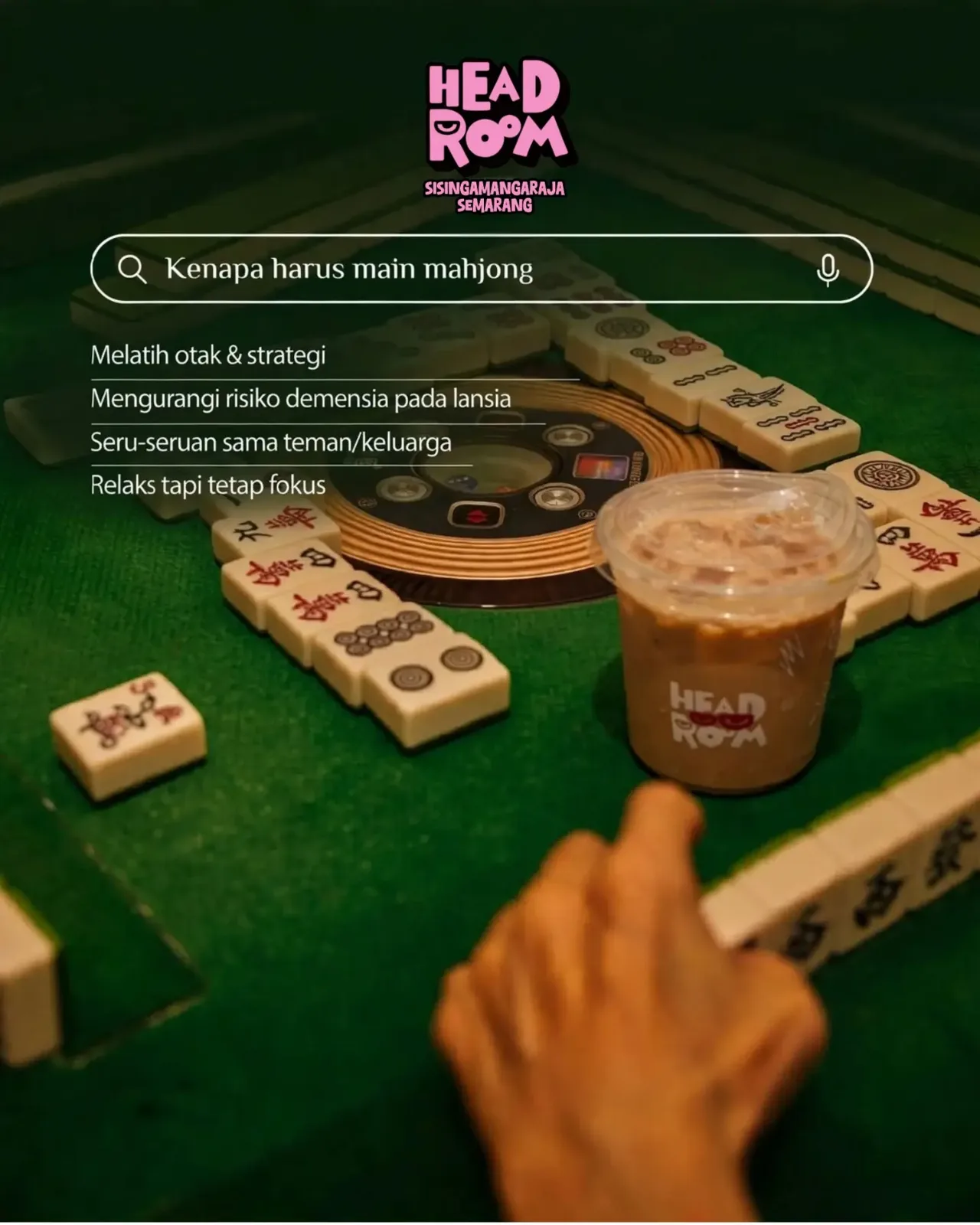 Tangan memainkan kartu mahjong di meja hijau dengan es kopi
