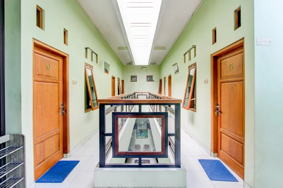 Lorong kamar eks Widitya Inn dengan pintu kayu dan dinding hijau muda