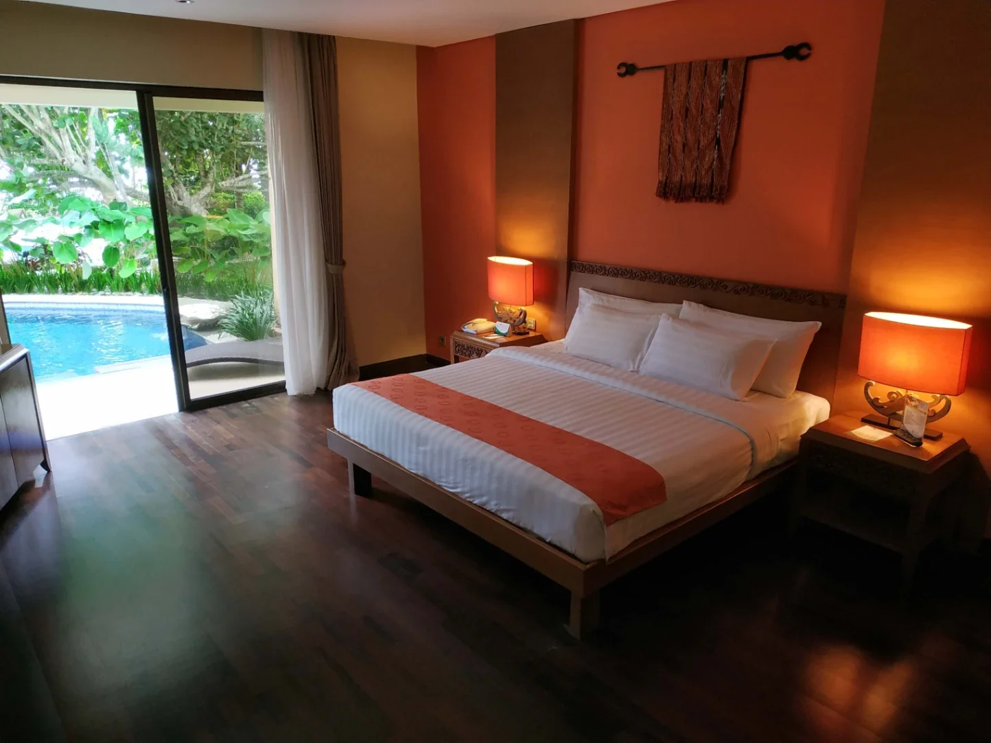 Kamar Junior Suite Lagoon The Natsepa dengan pintu kaca yang terbuka langsung ke kolam laguna