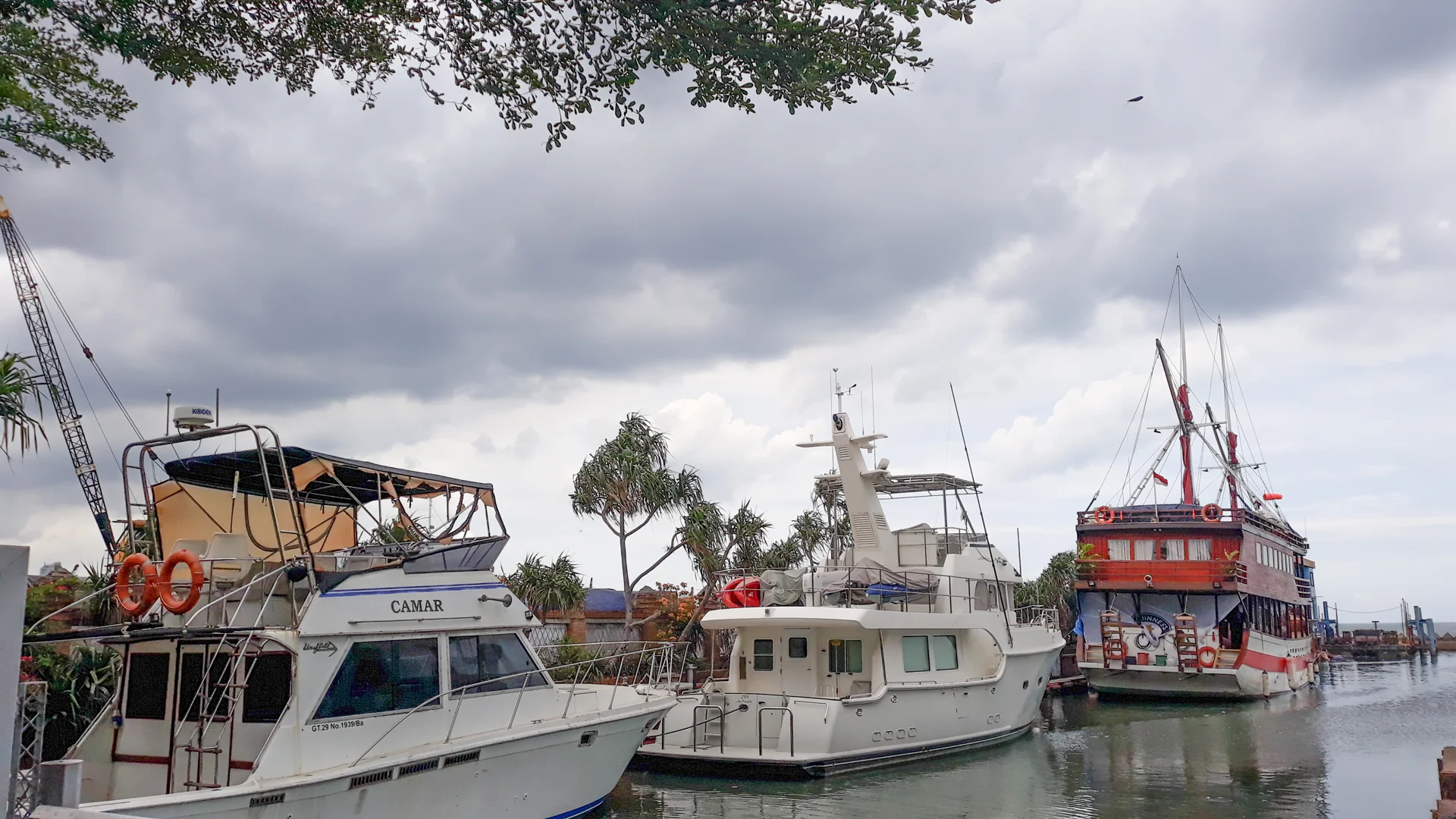 dua kapal motor pesiar putih dan kapal wisata bergaya kapal layar bersandar di Marina Ancol, Jakarta