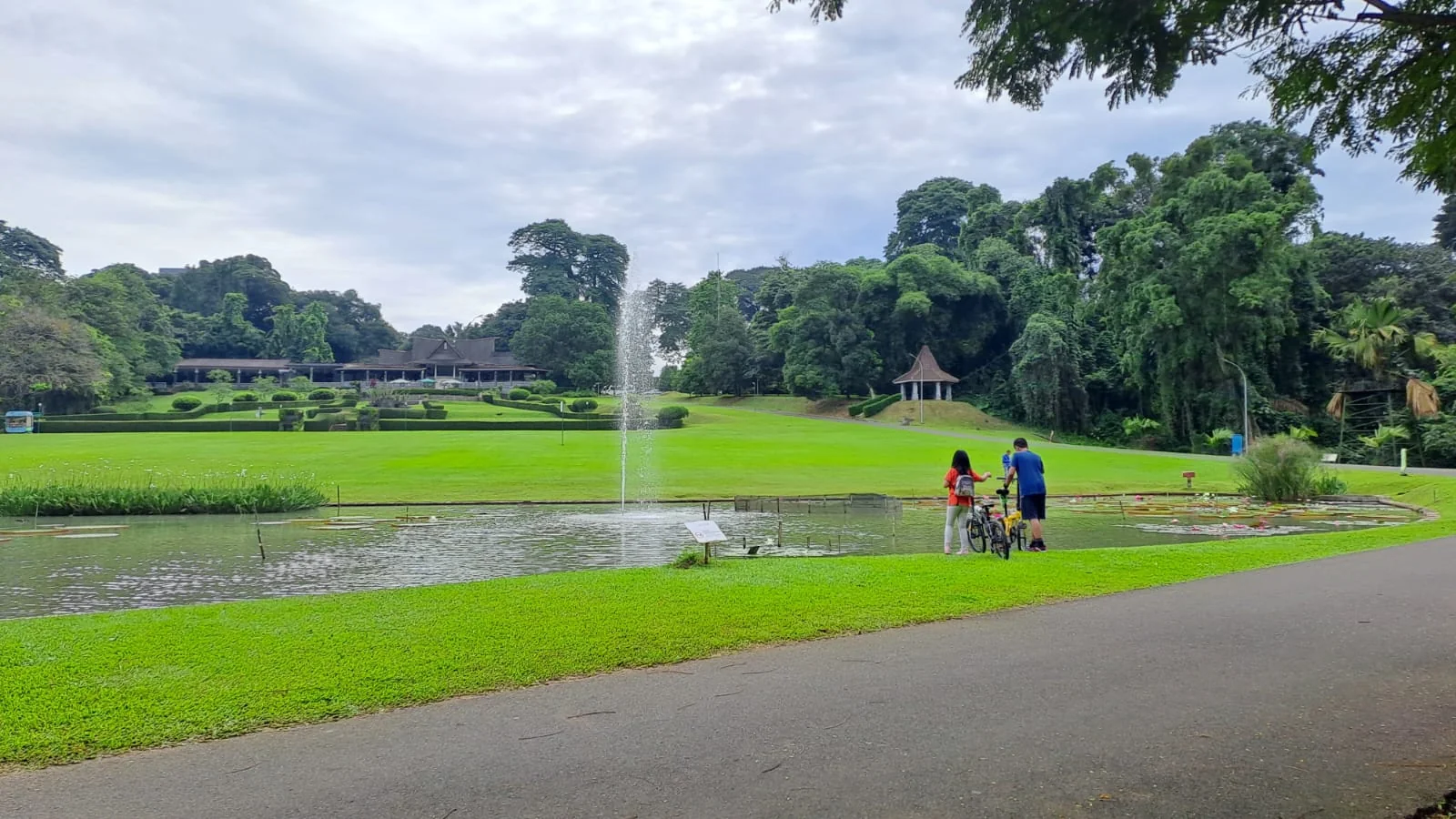 air mancur di Kolam Astrid Kebun Raya Bogor dengan rumput hijau dan pepohonan tinggi