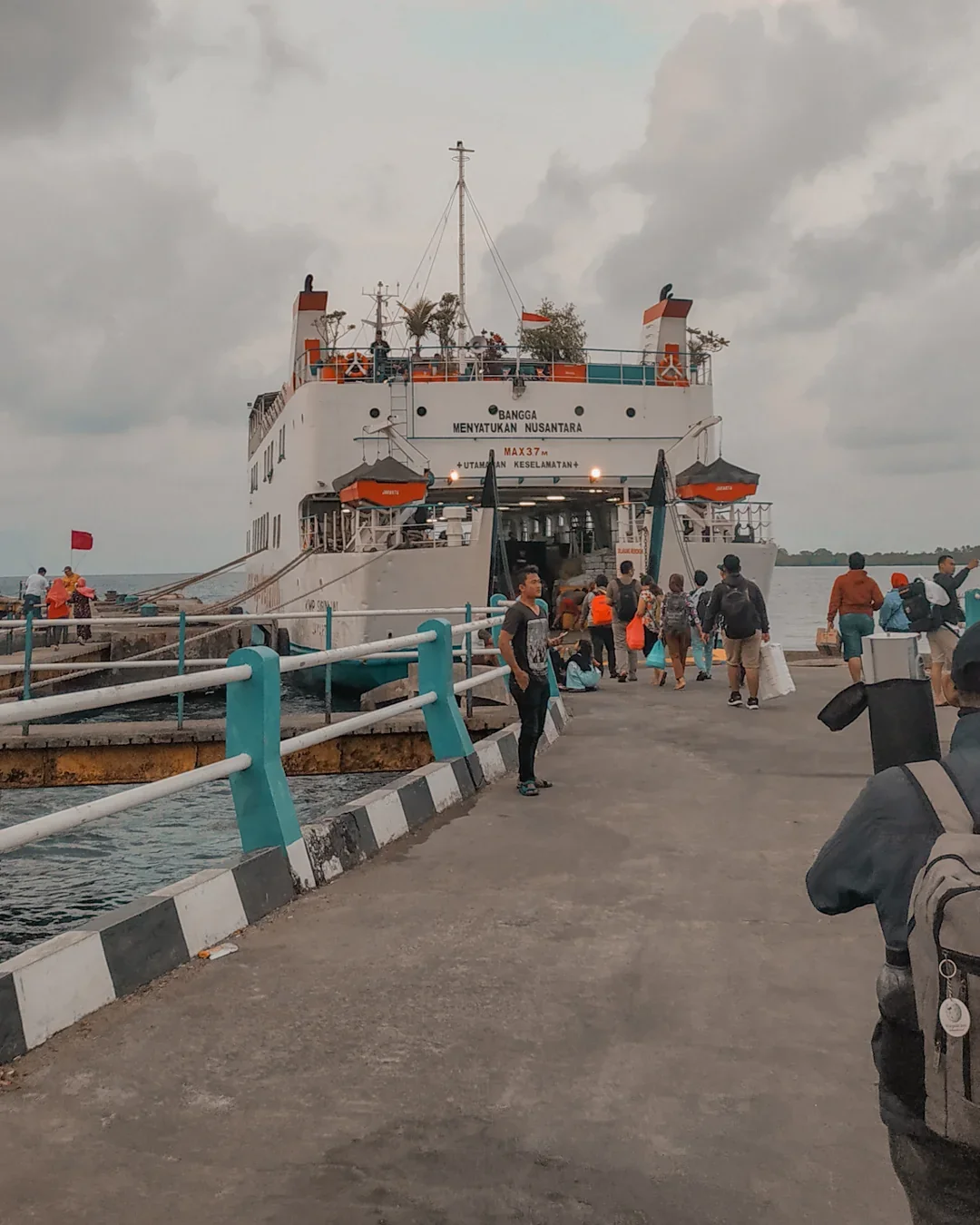 Penumpang berjalan di dermaga menuju KMP Siginjai yang bersandar