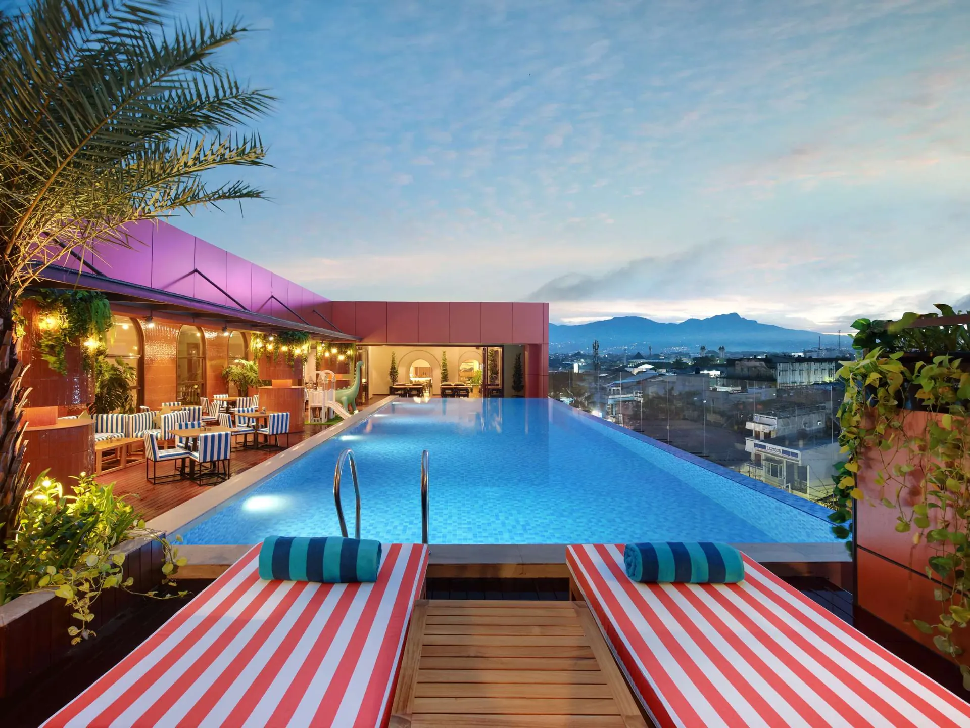 kolam infinity Mercure Garut City Center dengan kursi santai bergaris merah