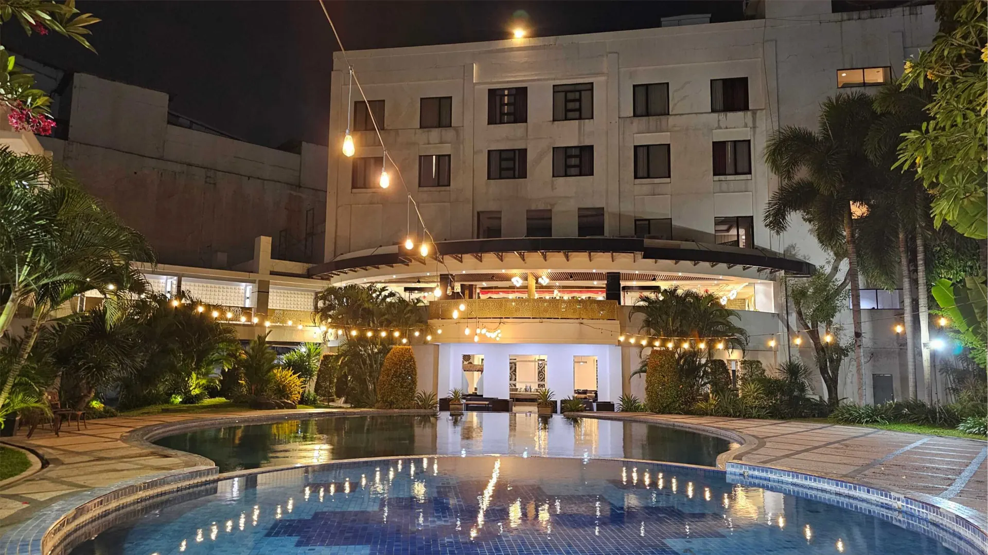 kolam renang The Sun Hotel Sidoarjo pada malam hari dengan lampu gantung di atas kolam