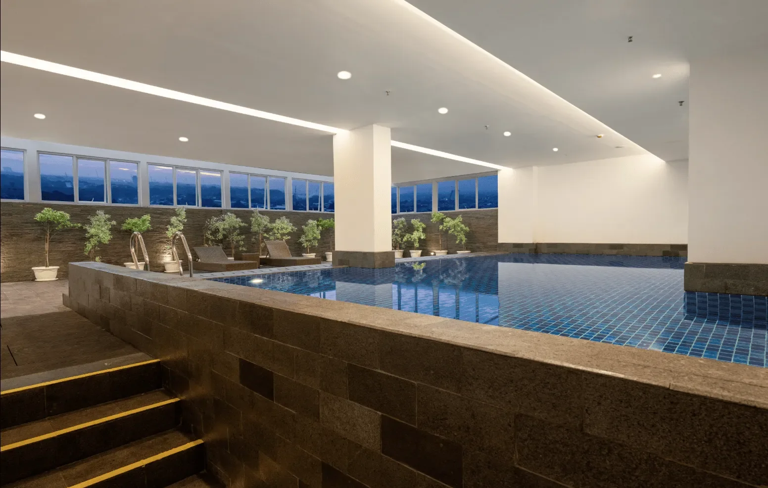 kolam renang beratap favehotel Karawang dengan jendela kaca menghadap kota