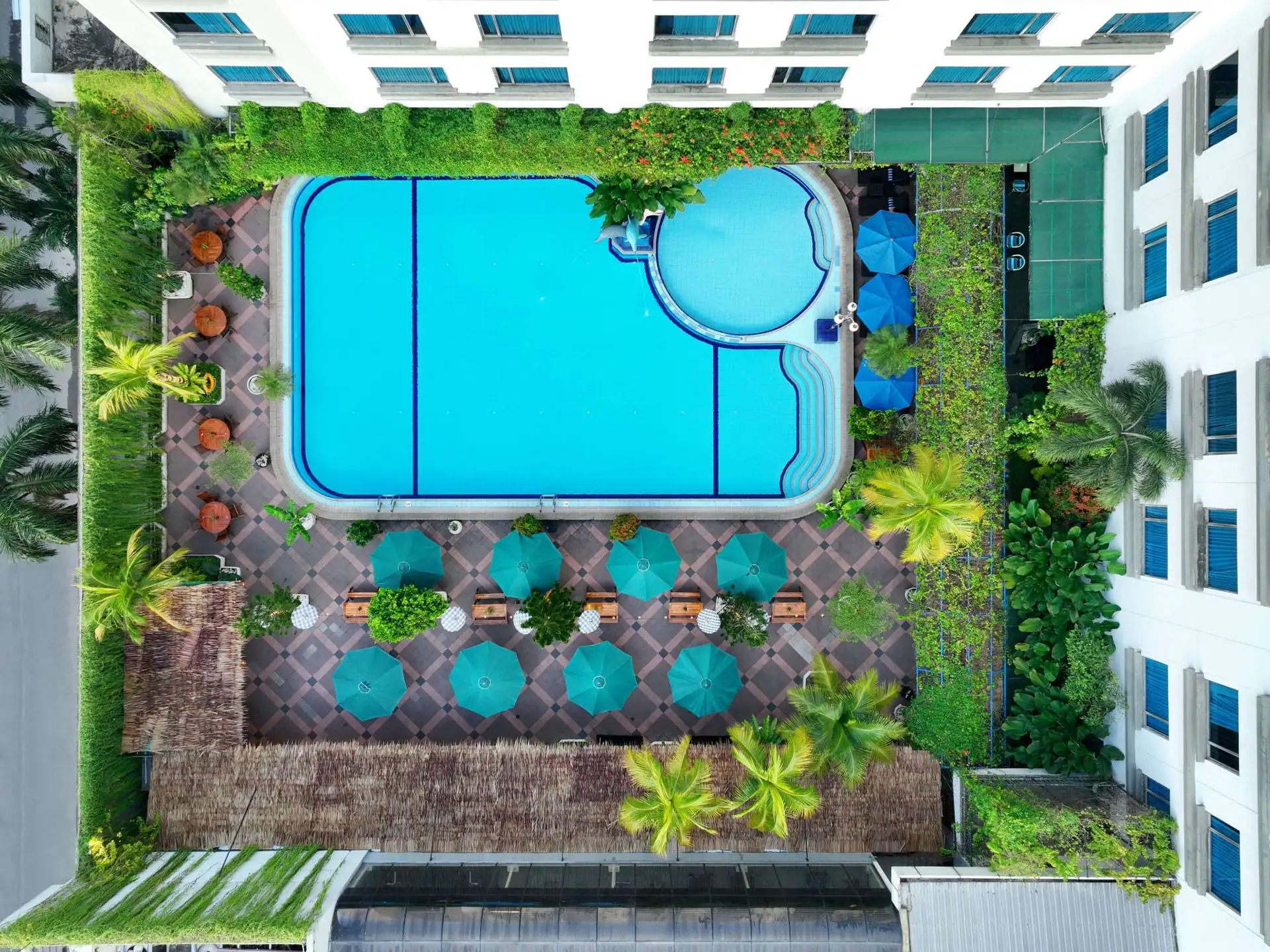 Kolam renang Grand Mercure Medan Angkasa dilihat dari atas dengan payung hijau di sekelilingnya