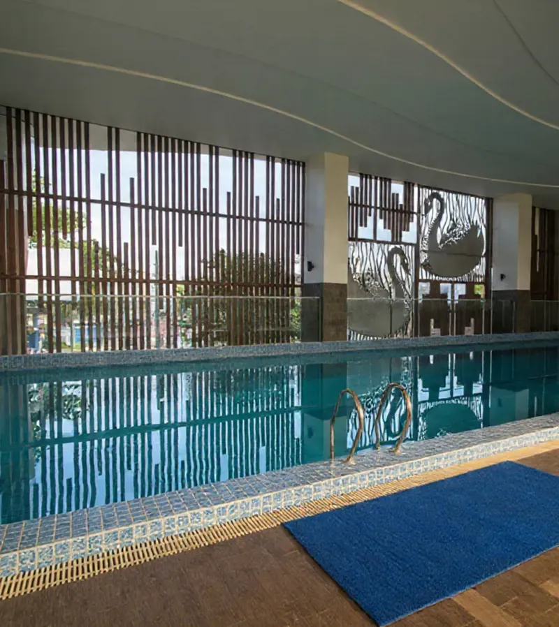 kolam renang indoor BW Luxury Jambi dengan dinding kisi kayu