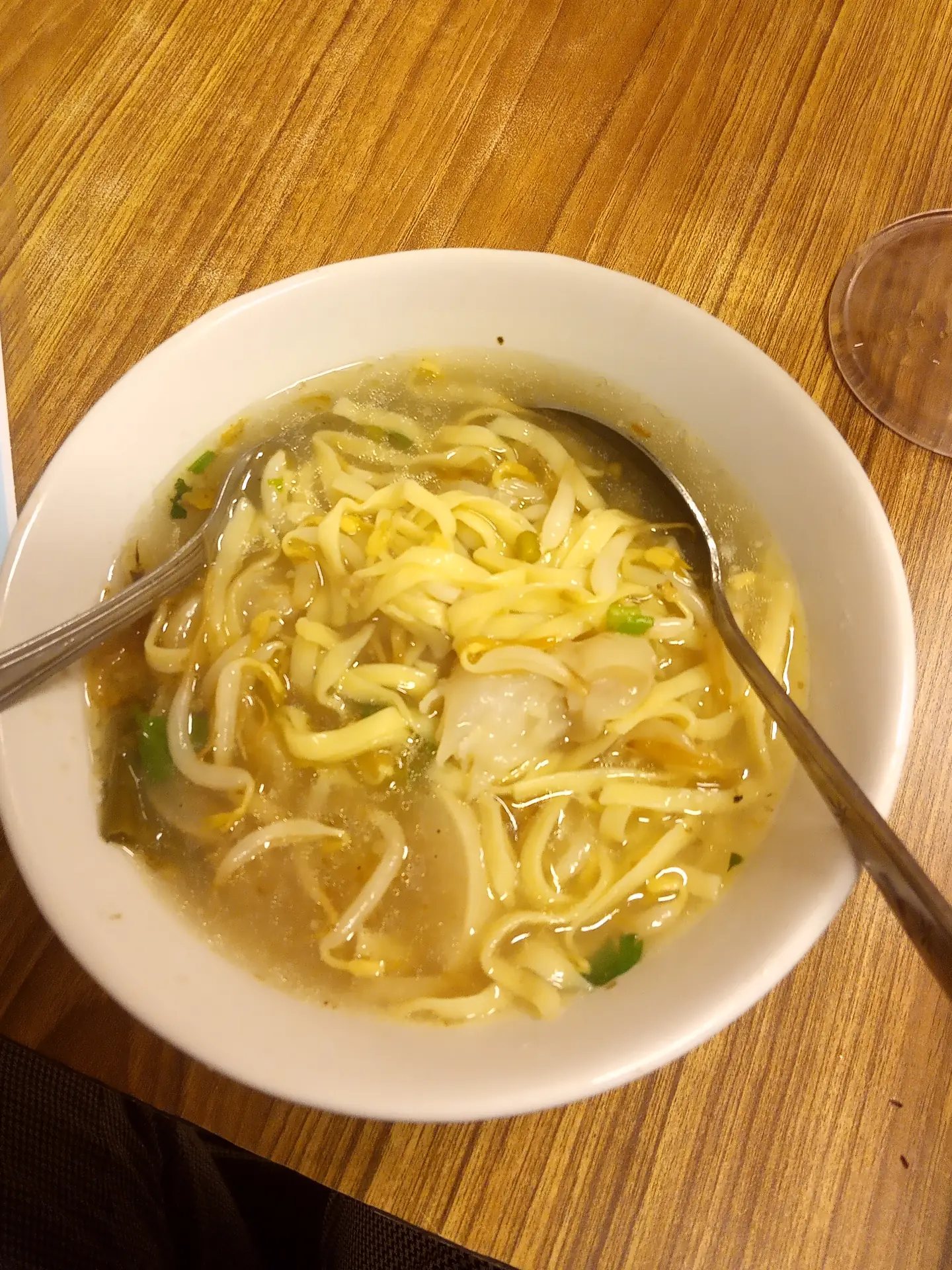 mi kuning pipih dan tauge dalam kuah kaldu keruh dengan dua sendok di mangkuk putih