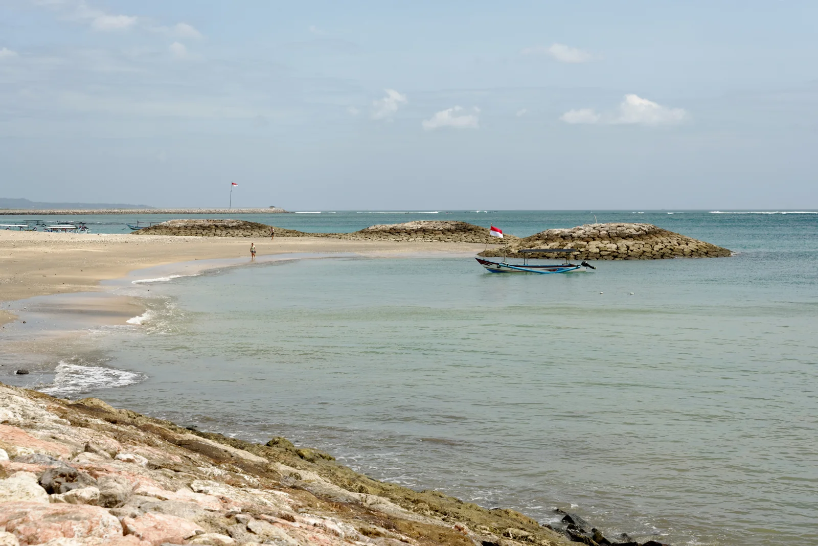 Pantai Jerman di Tuban, Kuta, Bali dengan air laut tenang dan pemecah ombak batu
