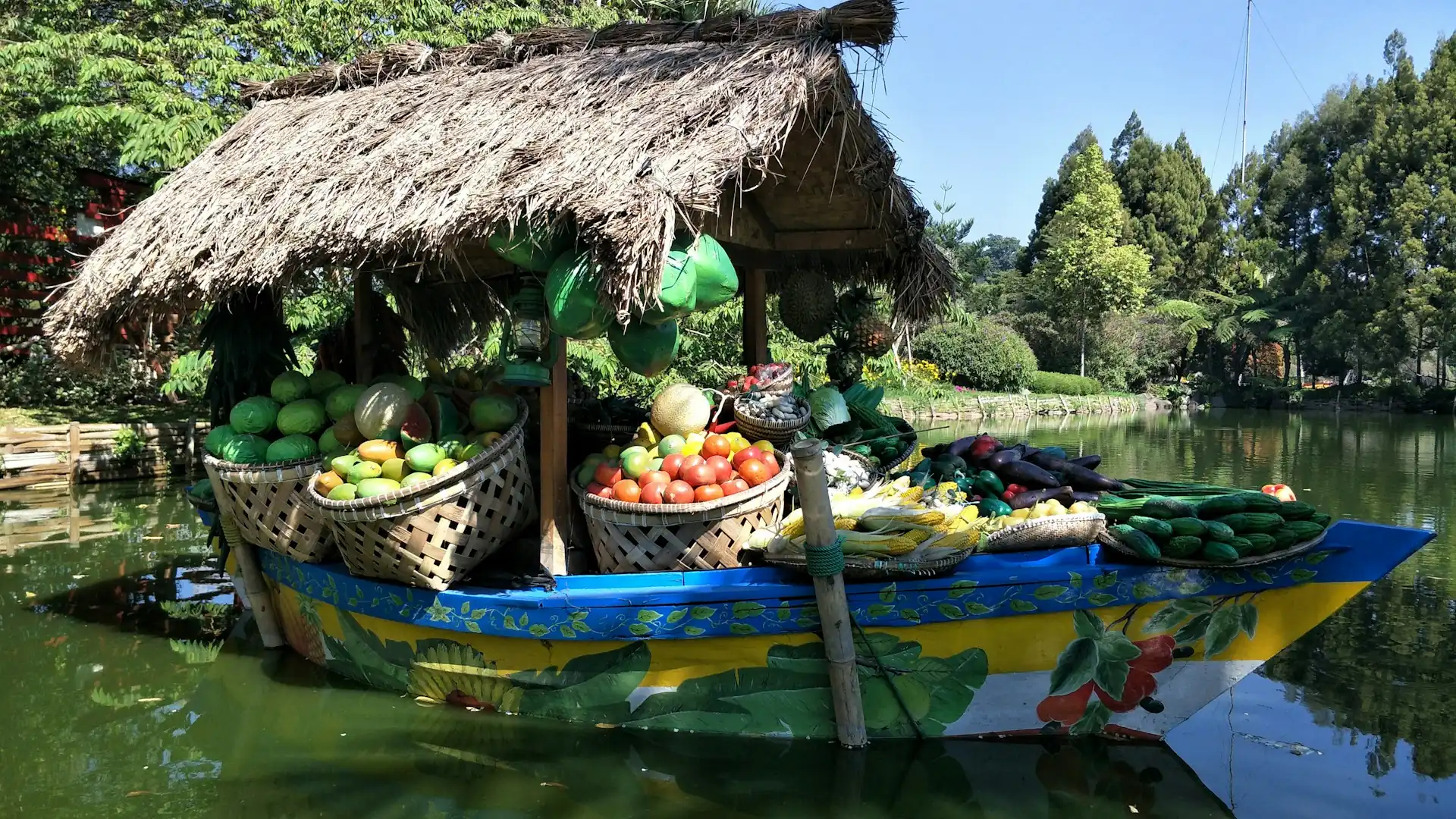 Perahu kayu berisi buah dan jajanan di pasar apung Floating Market Lembang