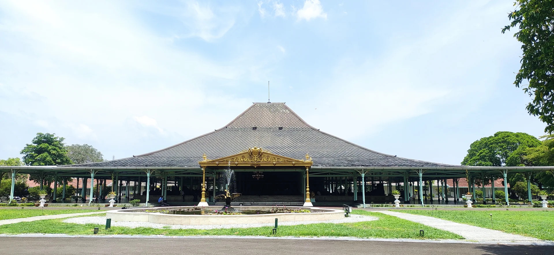Pendapa Ageng Pura Mangkunegaran beratap limasan dengan halaman rumput dan kolam bundar