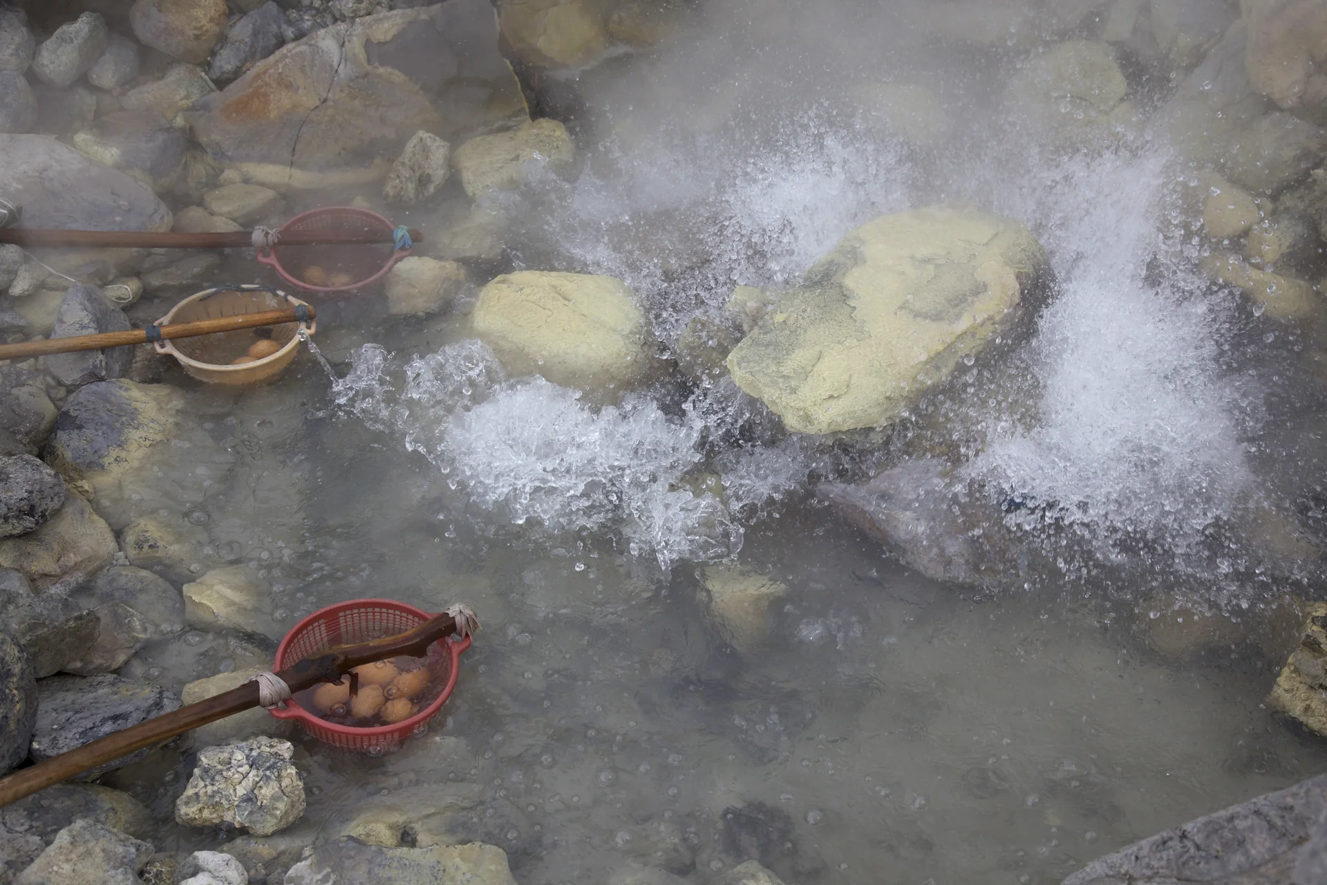 telur direbus dalam keranjang bertangkai di kolam air panas yang mendidih di Kawah Domas, Tangkuban Parahu