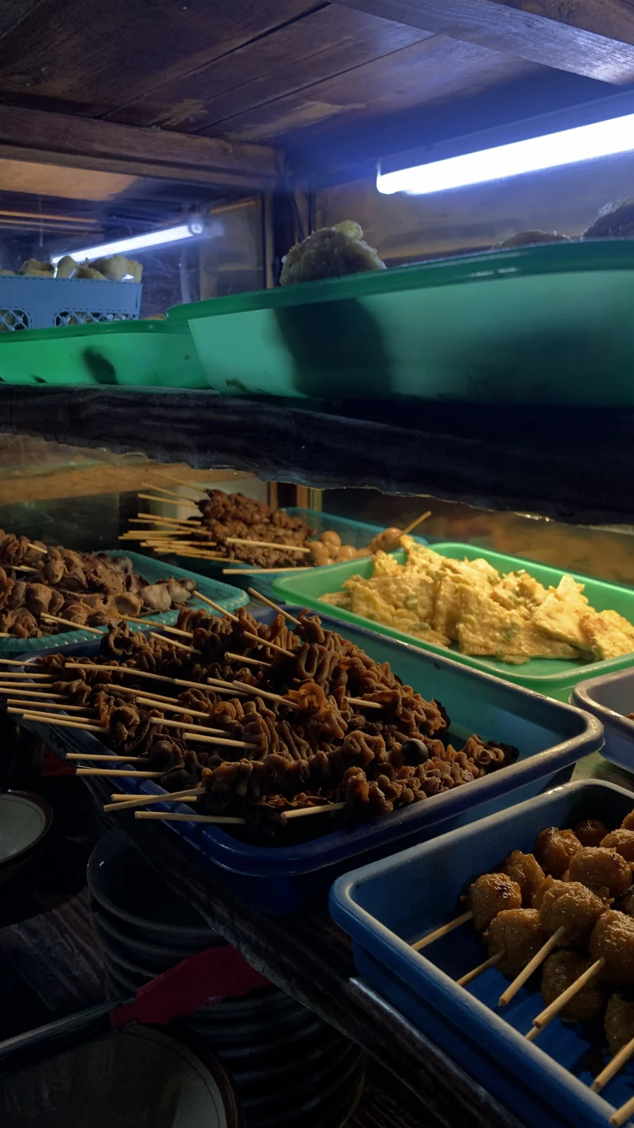 Sate usus, tempe goreng, dan bakso tusuk di etalase angkringan