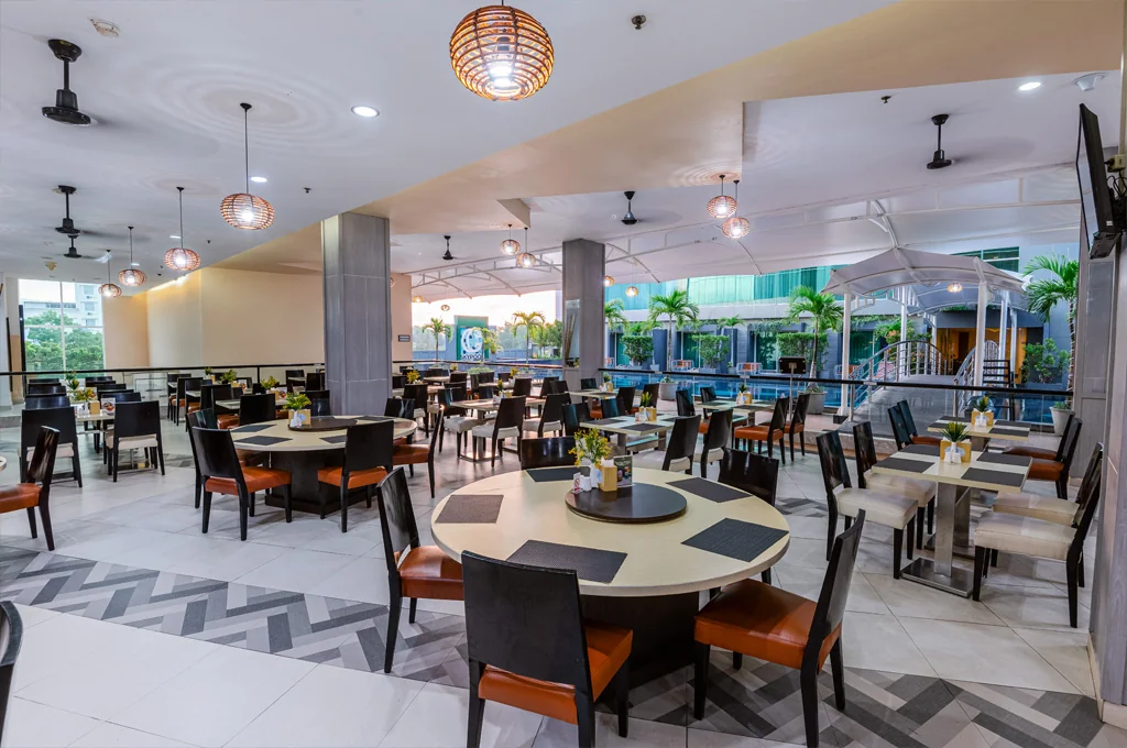 Area makan Sky Garden and Pool Claro Kendari dengan kolam renang di latar belakang