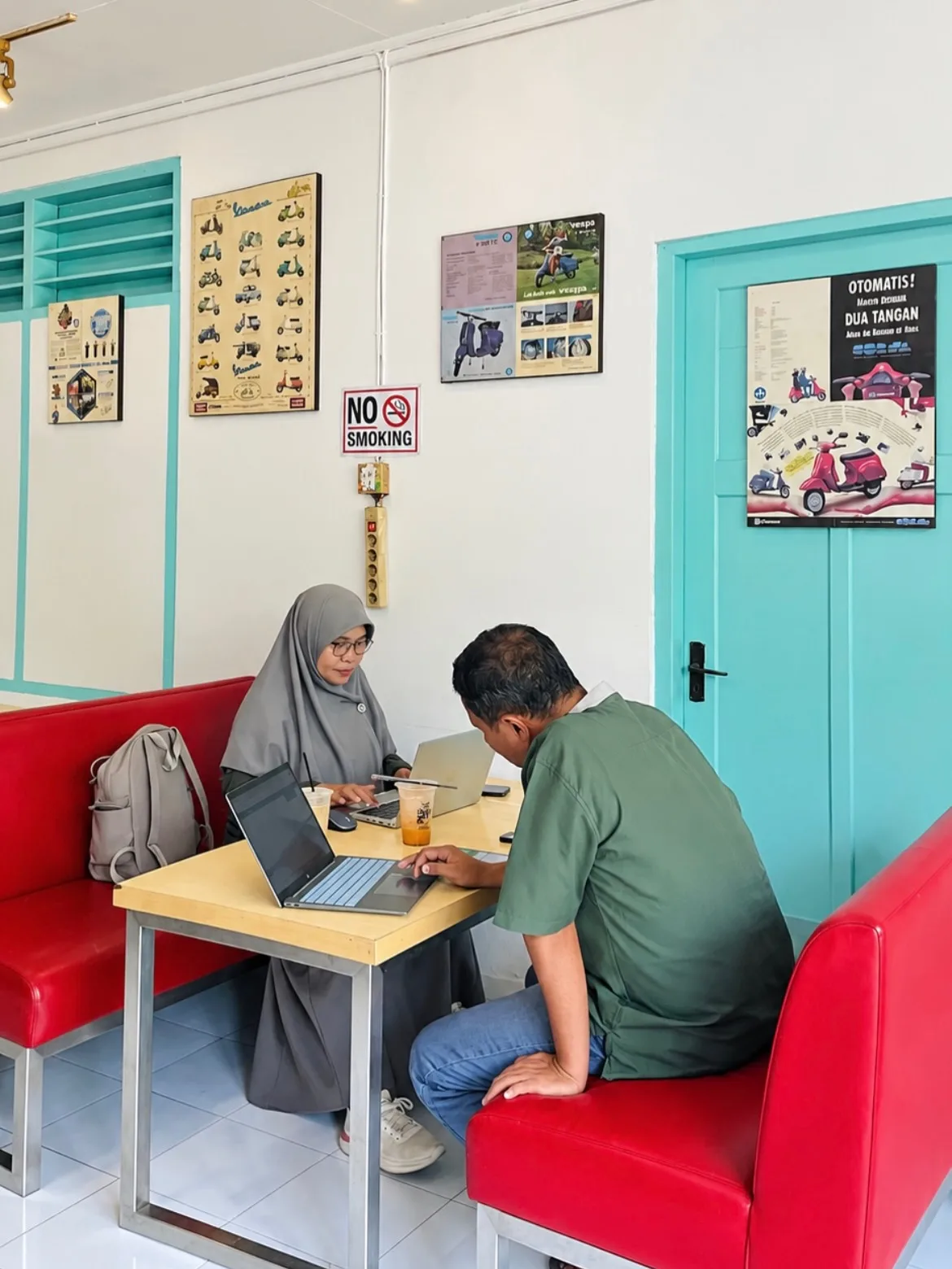 Pengunjung bekerja dengan laptop di sofa merah SS Coffee Space Makassar