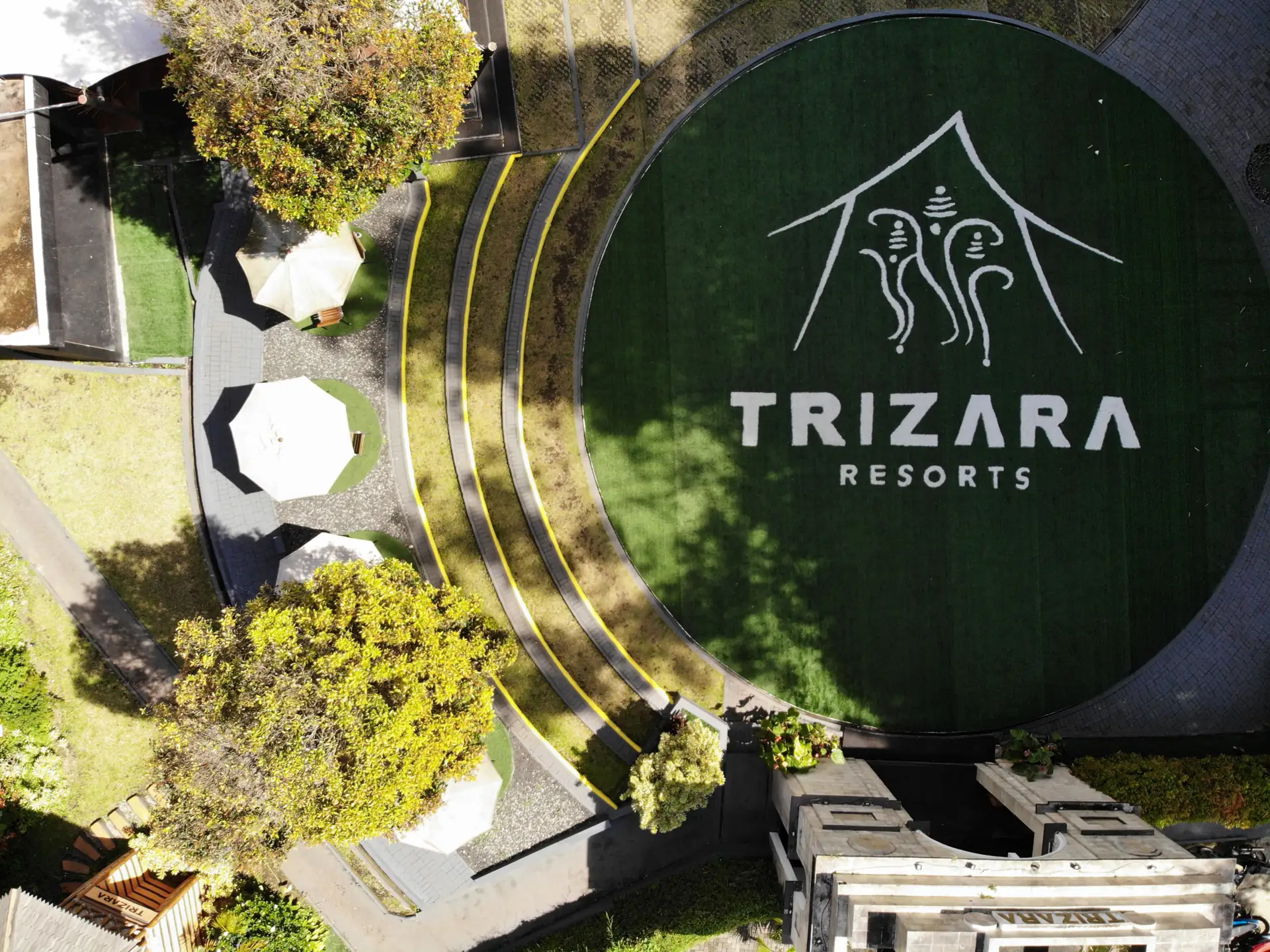 Foto udara area tengah Trizara Resorts Lembang dengan logo di lapangan rumput