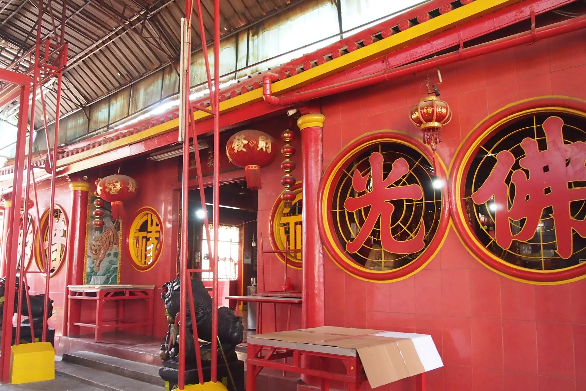 Dinding merah Kelenteng Jin De Yuan (Vihara Dharma Bhakti) di Petak Sembilan, Glodok, dengan aksara Tionghoa dalam bingkai bundar dan lampion merah