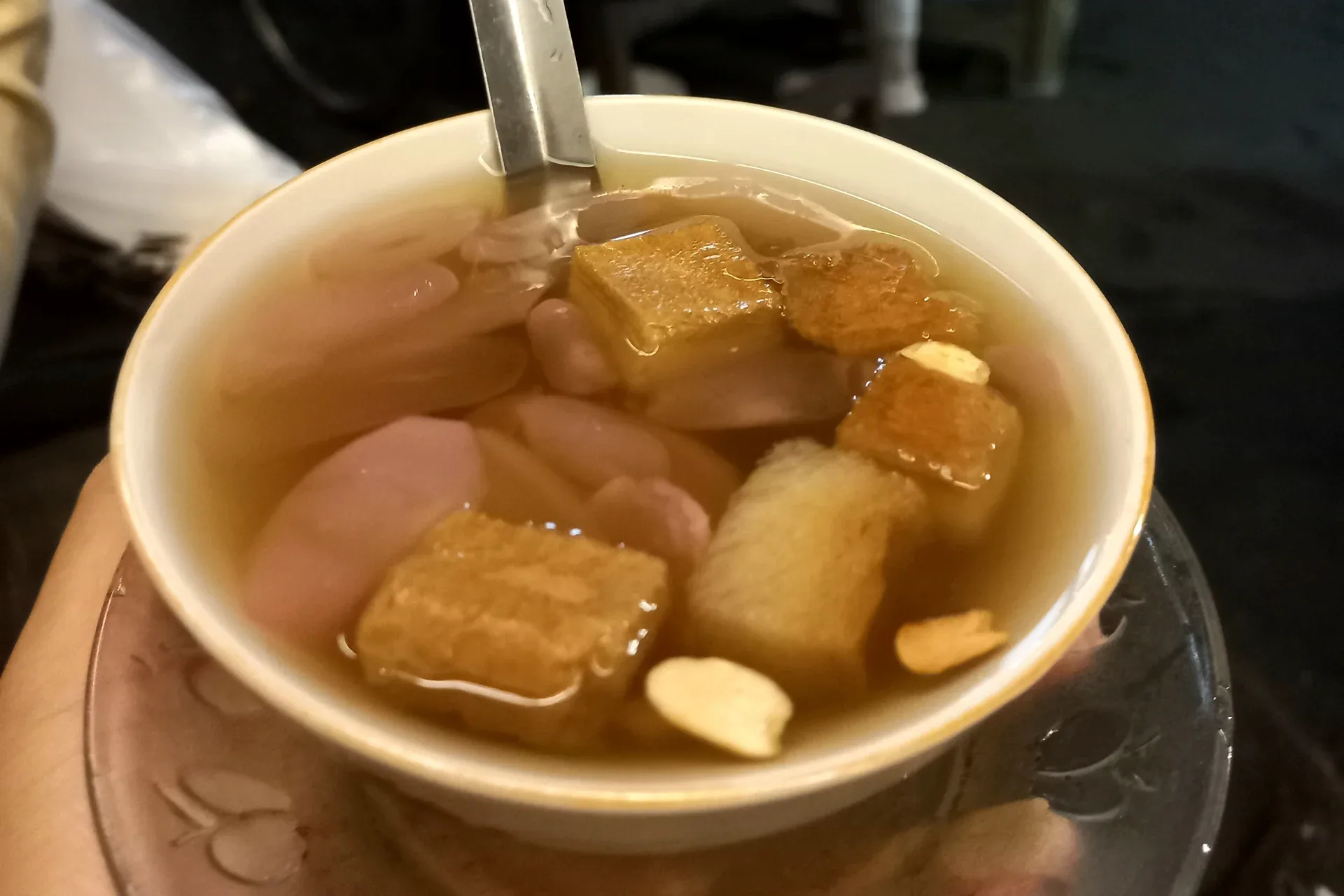 Semangkuk wedang ronde berkuah jahe berisi bola ronde, kolang-kaling, potongan roti, dan kacang tanah